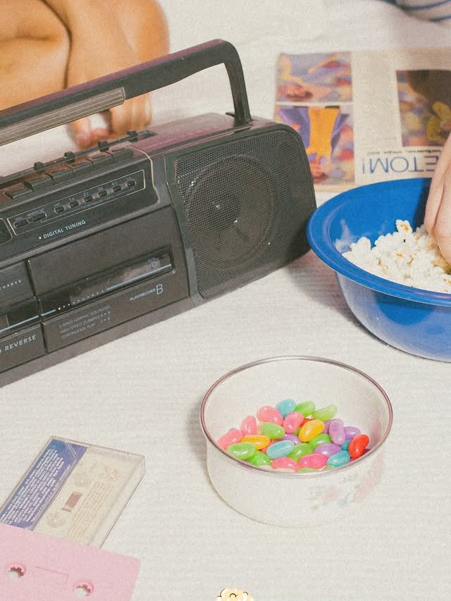 Mesa com boombox, pipoca e objetos retro